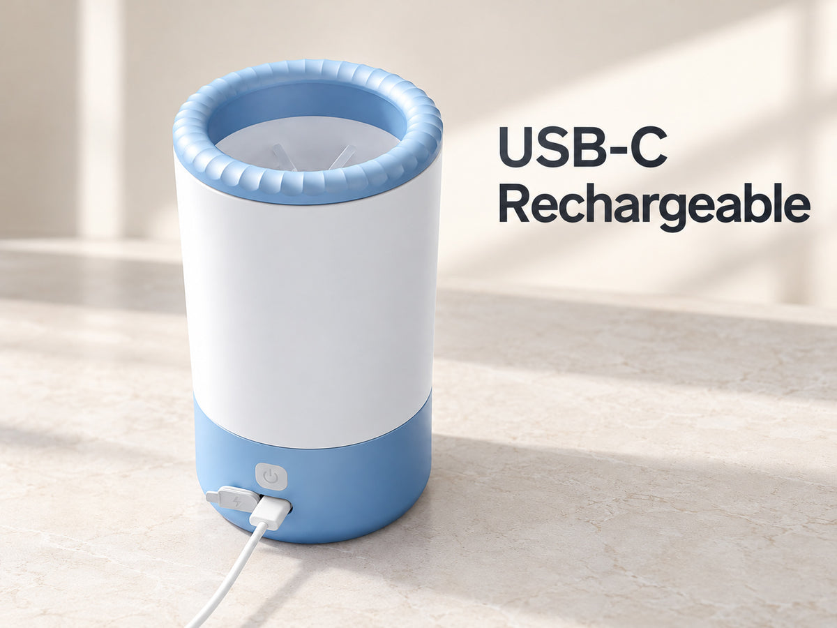 Blue and white electric dog paw cleaner with USB-C charging cable connected on a light countertop.
