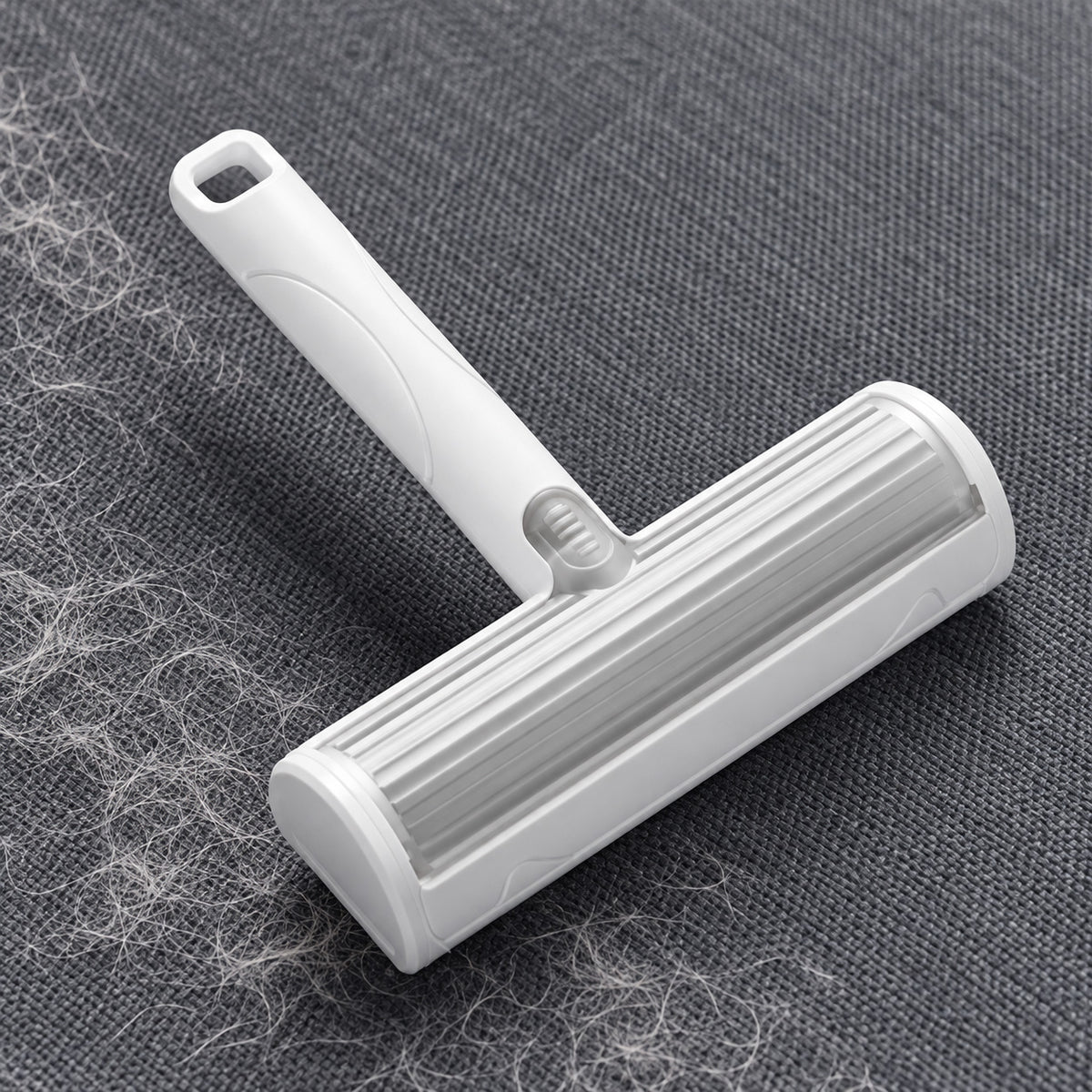 Reusable Pet Hair Remover Brush on grey fabric with loose pet hair